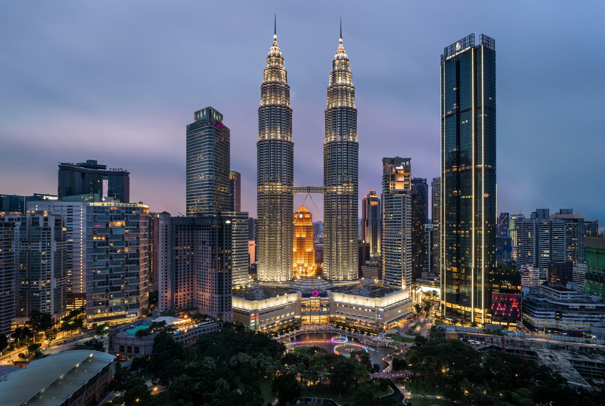 Kuala Lumpur skyline at blue hour, with the Petronas Towers illuminated against a dusk sky